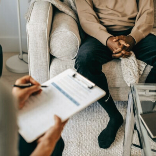 Physiotherapist and patient in a consultation room filling in a form to record patient information