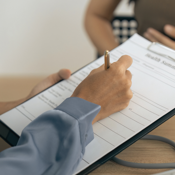 Person filling in a form on a clipboard